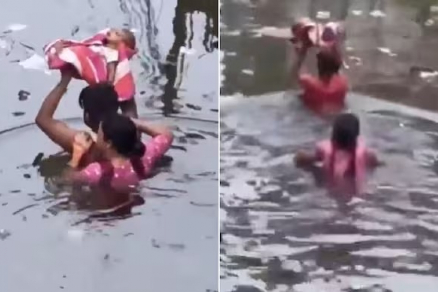 A couple walks in the rain, holding their newborn baby high in both arms.